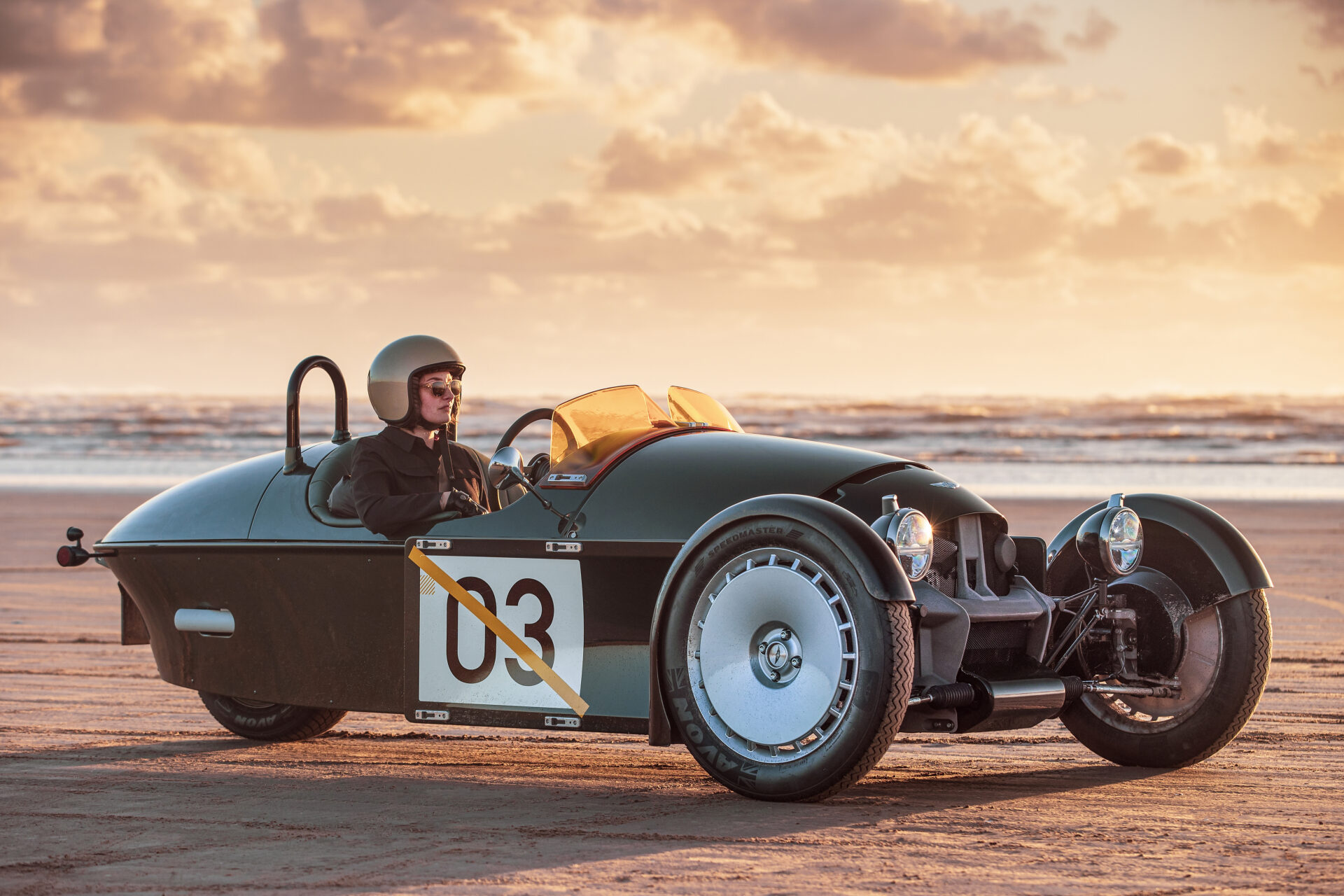 Front 3/4 of driver sat in static Super 3 on a beach.